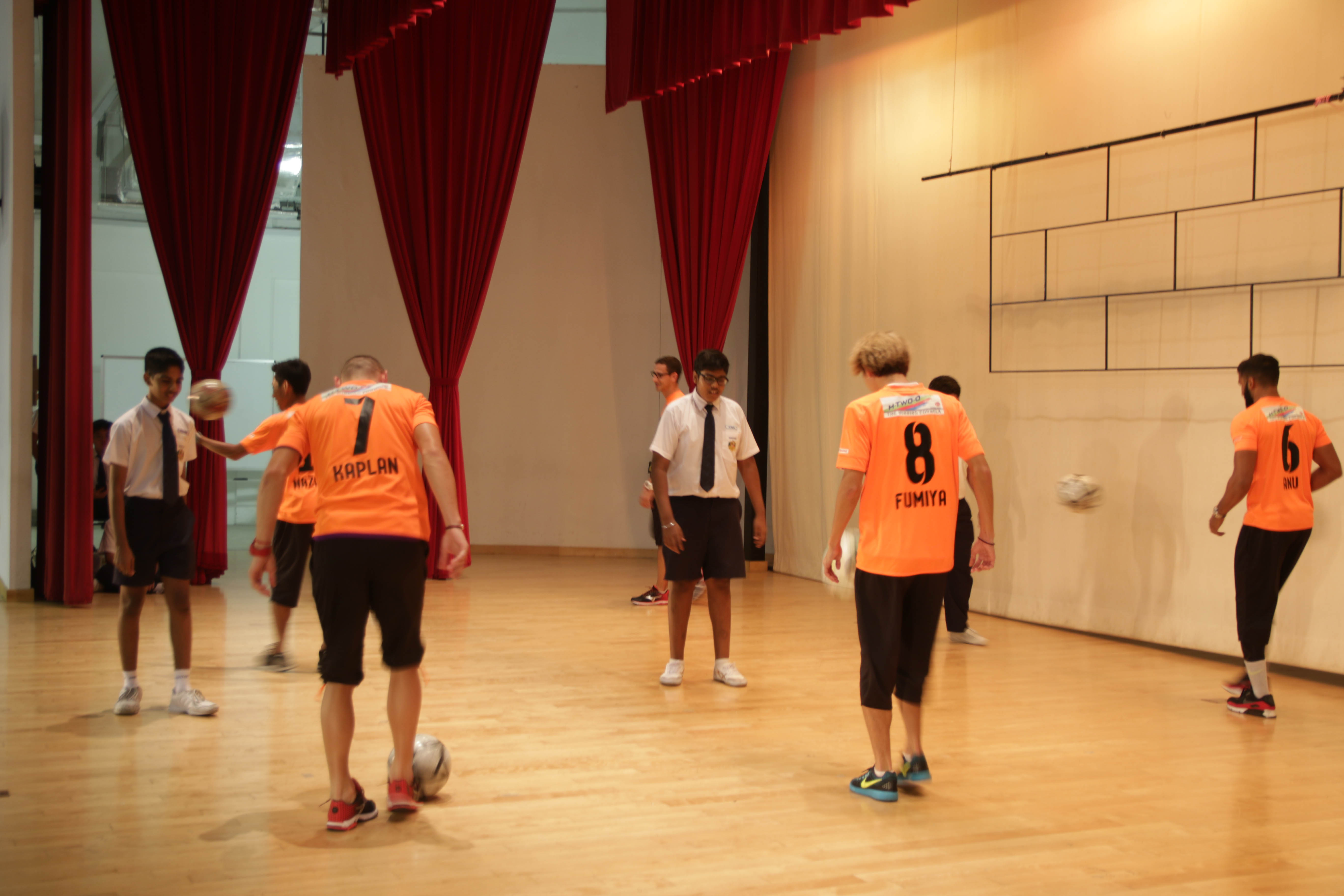 Students displaying their keepy-ups skill with the players.